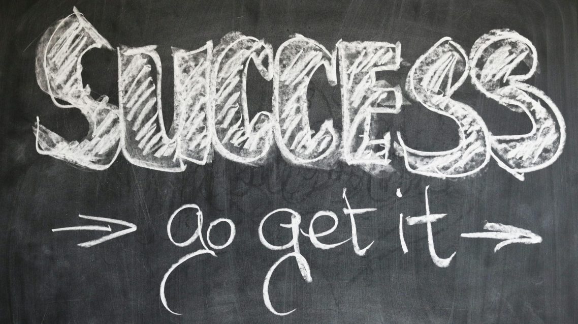 "Chalkboard with the words 'SUCCESS' and 'go get it' in decorative white lettering."